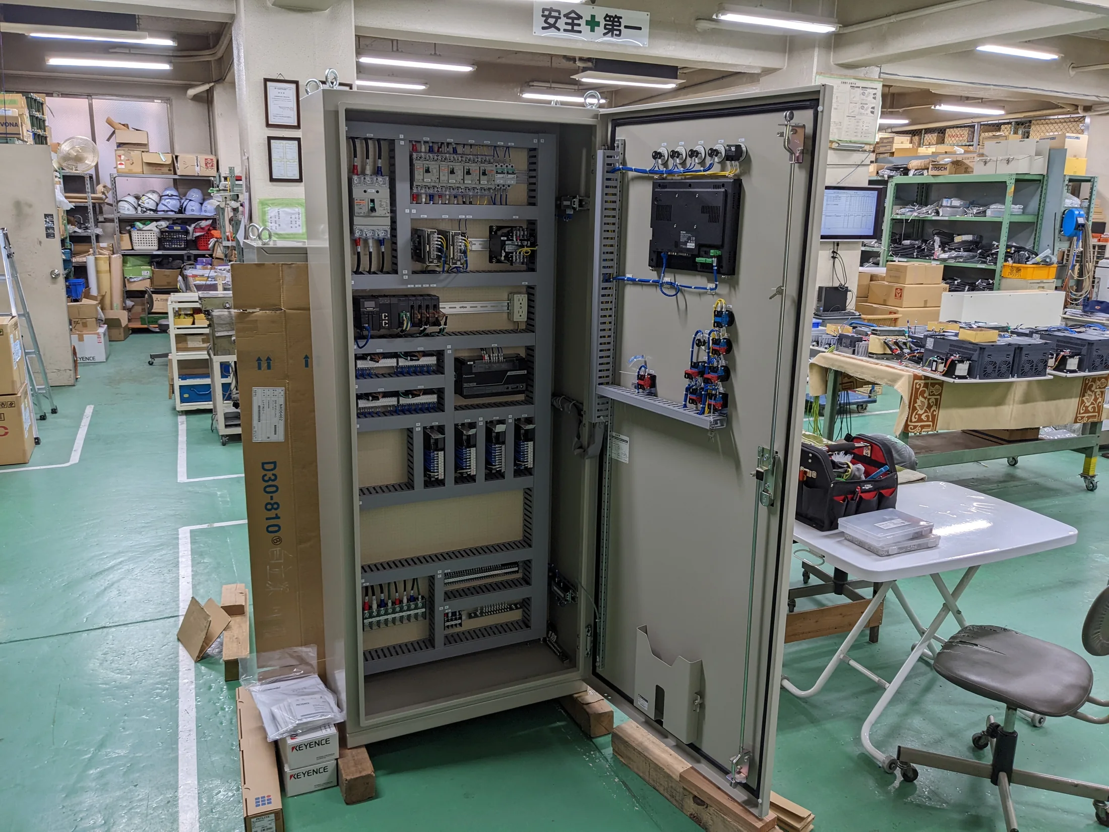 扉を開いた制御盤と盤内部の機器や配線