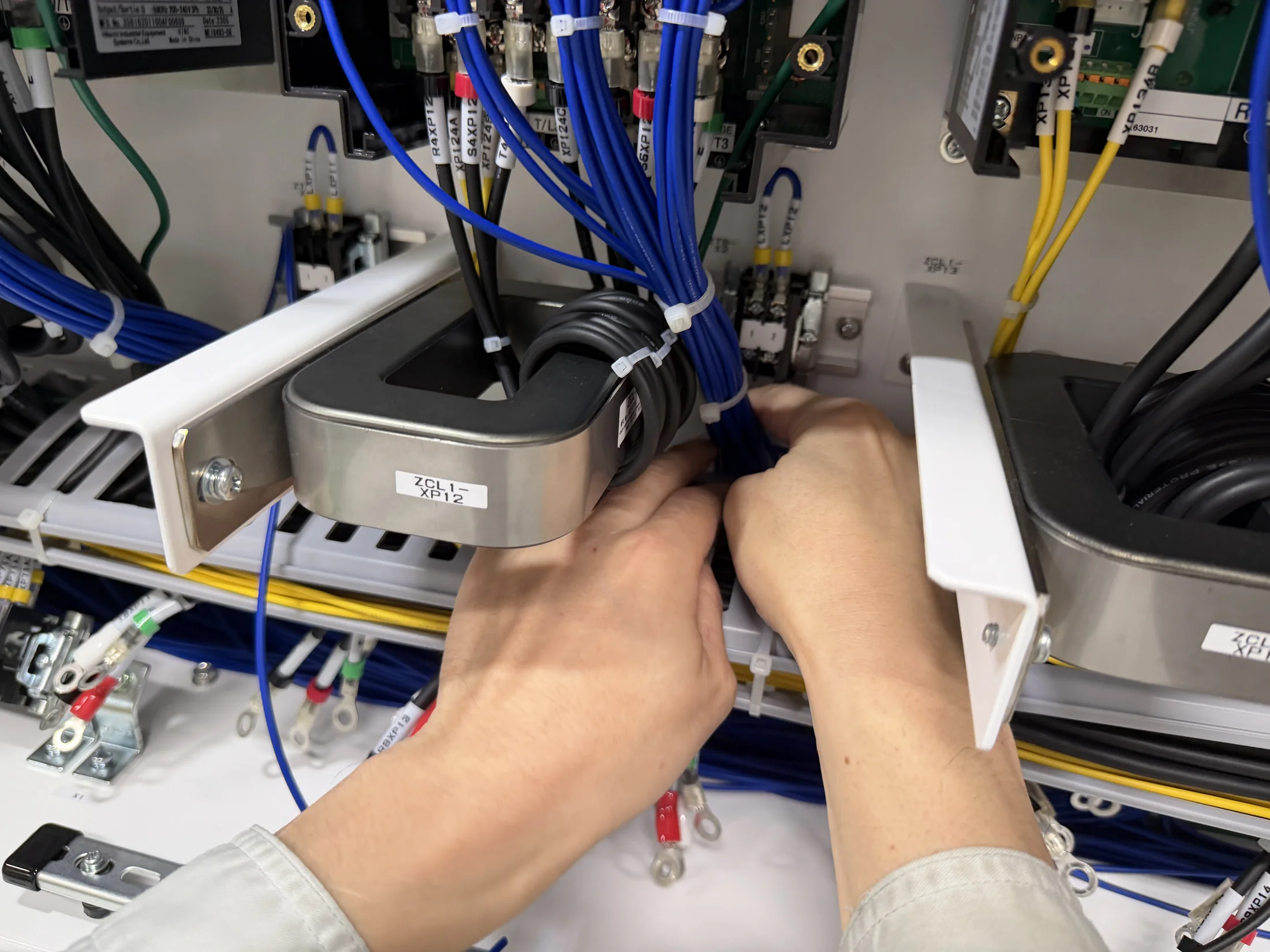 制御盤内部の機器と配線を扱う作業者の手元